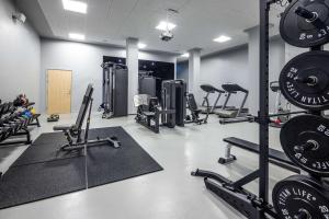 霍森斯Scandic Opus Horsens的一间健身房,配有数台跑步机和举重器材