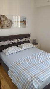 布德瓦Holiday Apartment的一间卧室配有一张带 ⁇ 子毯子的床