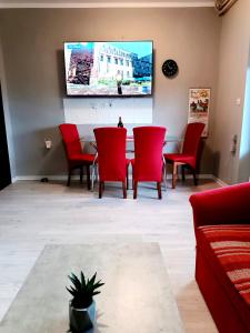 斯洛文尼亚科尼采Apartma Xanadu的客厅配有桌子和红色椅子