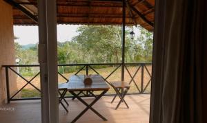 瓦亚纳德Bhuvi Wayanad Natural Tea Plantation Resort的客房设有一张桌子和一个美景阳台。