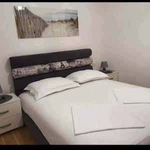 布德瓦Holiday Apartment的卧室内的一张带两个枕头的白色床