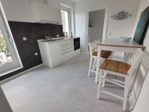 阿尔布斯塔特Ferienwohnung und Monteurzimmer的厨房配有白色橱柜和桌椅