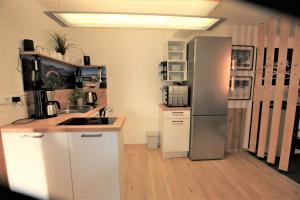 DriedorfWesterwald Apartment DRIE600的厨房配有白色橱柜和冰箱。