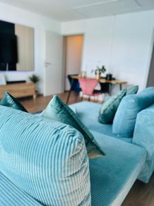 萨尔布吕肯Penthouse, Sonnenbalkon, Netflix的客厅配有带枕头的蓝色沙发