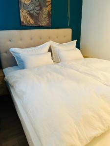 萨尔布吕肯Penthouse, Sonnenbalkon, Netflix的一张白色大床,配有白色床单和枕头