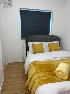 斯蒂夫尼奇Stevenage Studios - Superior Suite的一间卧室配有一张带黄色枕头的大床