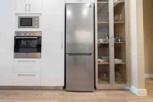 开普敦522 The Granger的一间厨房内的不锈钢冰箱,厨房内有白色的橱柜