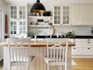 斯德哥尔摩Holiday home SPÅNGA的厨房配有白色橱柜和桌椅