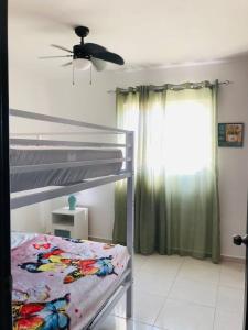 拉罗马纳Apartamento amueblado的一间卧室配有一张双层床和吊扇