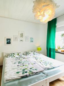 维勒斯威特Eifel-House - FeWo的一间卧室配有一张床和一个吊灯
