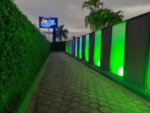 平达莫尼扬加巴Motel Prestige Pinda的人行道上带绿灯的围栏