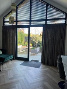 Velserbroek Cozy & Modern Tiny House的客厅设有通往庭院的大玻璃门