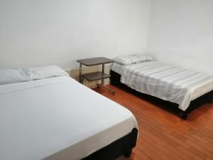 波帕扬Hotel El Carretero的两张床铺位于一个房间,中间有桌子