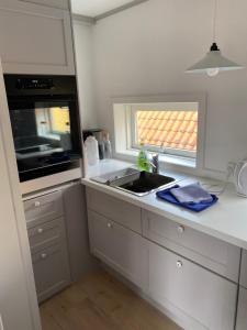 斯卡恩Skagen Bo Godt Kirkevej的白色的厨房设有水槽和窗户