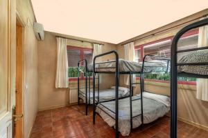 吉桑多El Bosque de la Herrezuela的客房设有三张双层床和一扇窗户。
