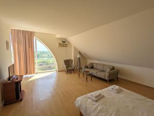 Ianet'iHotel Tsiskari的客房设有床、沙发和窗户。