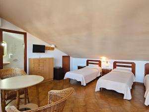 马尔格莱特德玛Hotel Blue Spot的一间设有两张床和一张桌子及椅子的房间