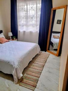KiraLovely Double Bed with a Private Garden Nook的一间卧室配有一张大床和镜子
