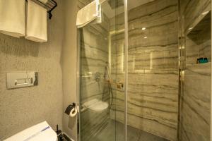 博德鲁姆Gündoğan Suites的一间带卫生间和玻璃淋浴间的浴室