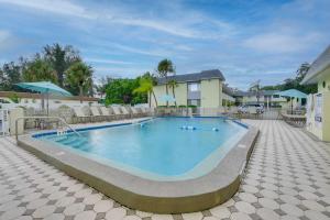 萨拉索塔Siesta Key Condo with Heated Pool Less Than 1 Mi to Beach的一座带椅子的大型游泳池和一座建筑