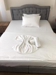 YıldırımEylül suit otel的一张带白色毯子和枕头的床