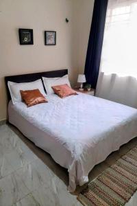 KiraLovely Double Bed with a Private Garden Nook的卧室内的一张带两个枕头的床