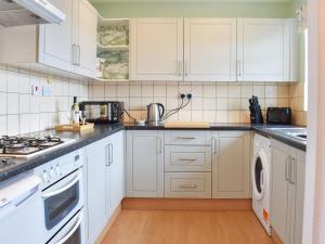 赖顿Meadowfield View的厨房配有白色橱柜和白色家电