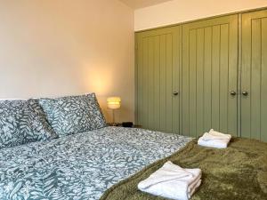 格洛索普Pennies Retreat的一间卧室配有一张蓝色和绿色床单。