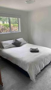 Wairoa‘The Don’ on Hillcrest的白色卧室内的一张床位,卧室设有窗户