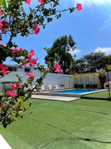 万查科HUANCHACO GARDENS的一座带游泳池和粉红色鲜花的建筑