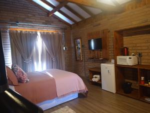 坎巴拉Chalés Corucacas的一间卧室配有一张床和一个微波炉