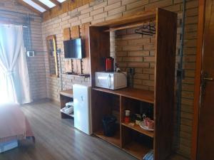 坎巴拉Chalés Corucacas的客房内的厨房配有微波炉和冰箱