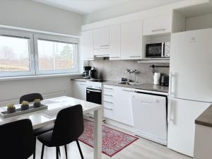 哈米纳Hamina City Apartments的厨房配有白色家电和桌椅