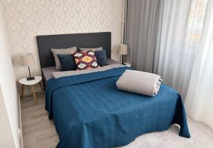 哈米纳Hamina City Apartments的一间卧室配有一张带蓝色毯子的床