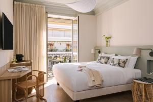尼斯Yelo Mozart powered by Sonder的配有一张床、一张书桌和一扇窗户的酒店客房