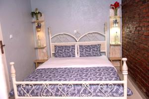 鲁亨盖里Little Birds Paradise的卧室配有白色的床和砖墙