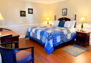 卡姆登锡达克雷斯特酒店的一间卧室配有一张带蓝白色毯子的床