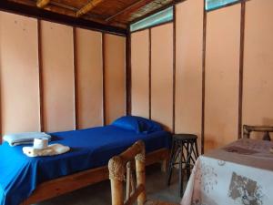 曼克拉Los Almendros de Máncora的卧室配有一张床铺,位于带桌子的房间