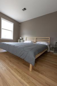泽西市Mins from NYC Bright & Spacious 4-Bed Unit的一间卧室配有一张大床和木制床头板