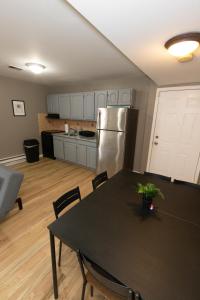 泽西市Mins from NYC Bright & Spacious 4-Bed Unit的厨房配有桌子和不锈钢冰箱。