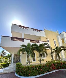 罗阿坦Villa de 2 habitaciones frente al mar Roatán的一座棕榈树的黄色建筑