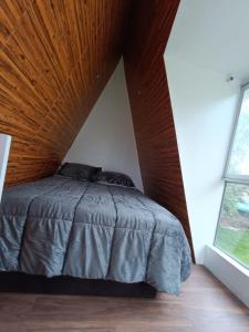 MuyurinaVallecito Lodge的一间卧室设有一张木天花板床。