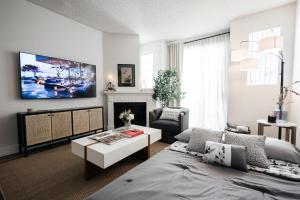 洛杉矶Ruby 2 BR apt in MiracleMile的客厅配有床、桌子和电视