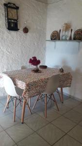 KoítaΠέτρινο σπίτι-Stone house的桌子上摆放着椅子,花瓶上放着花