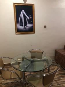 JiduDazzle Hotels and Apartments的一张玻璃桌,配有两把椅子和一张墙上的照片