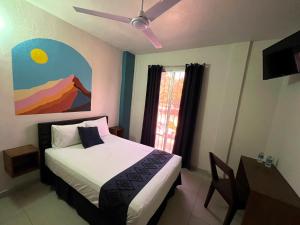 科利马Hotel Juarez 70的一间卧室配有一张床和吊扇