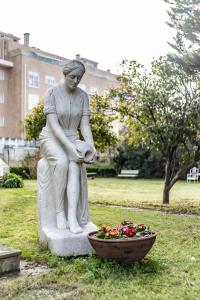 埃斯平霍Espinho Vintage - Alojamento de Charme的坐在一碗鲜花旁的女人的雕像