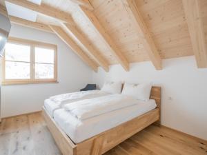 多内尔斯巴赫瓦尔德Bergzauber的一间带一张大床的卧室,位于一个拥有木制天花板的房间