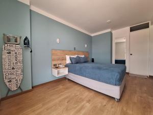 莫克瓜Hotel Tierra del Sol Moquegua的一间卧室设有蓝色的床,铺有木地板。