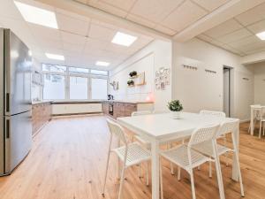 杜塞尔多夫RAJ Living - City Apartments with 5 Rooms - 10 Min Messe DUS的厨房以及带白色桌椅的用餐室。
